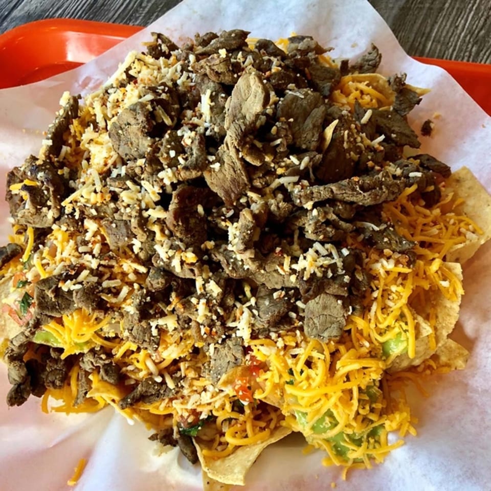 Roberto's Taco Shop carne asada nachos with shredded cheese, avocado, and pico de gallo.